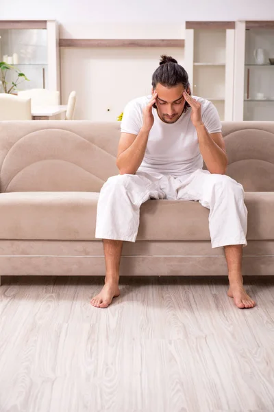 Young man doing physical exercises at home — Stock Photo, Image