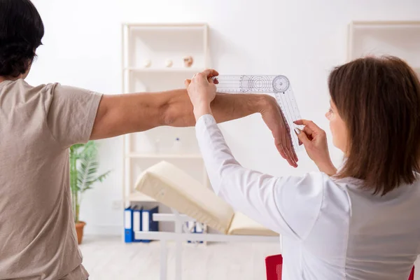 Médico femenino revisando pacientes flexibilidad articular con goniómetro — Foto de Stock