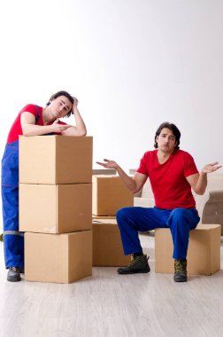 İki genç müteahhit kişisel eşyalarını taşıyor.