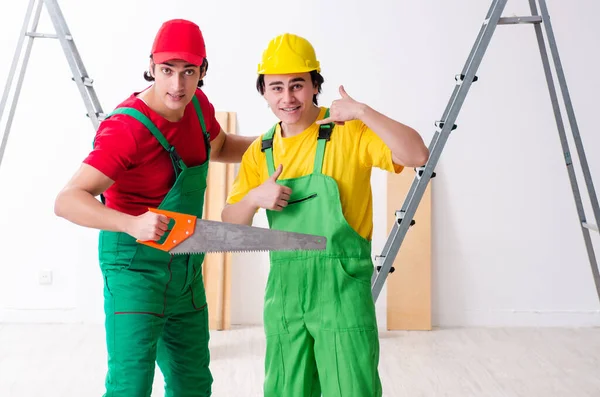 Dois trabalhadores empreiteiros que trabalham dentro de casa — Fotografia de Stock