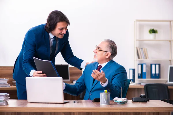 Empregados jovens e velhos trabalhando juntos no escritório — Fotografia de Stock