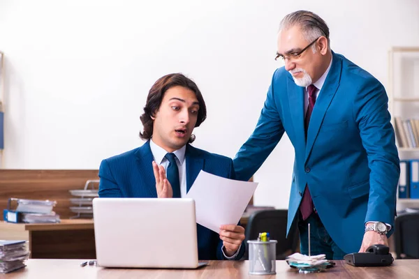 Empregados jovens e velhos trabalhando juntos no escritório — Fotografia de Stock