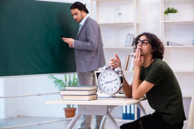 Genç öğretmen ve öğrenci sınıfta.