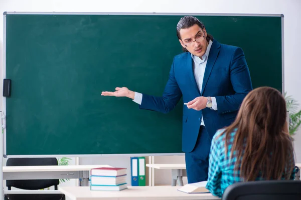 Jonge knappe leraar en vrouwelijke student in de klas — Stockfoto