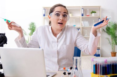 Laboratuvarda çalışan genç bir kadın kimyager.