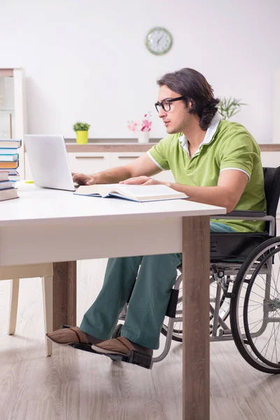 Jonge mannelijke student in rolstoel thuis — Stockfoto