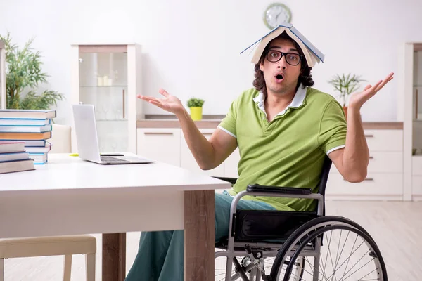 Jovem estudante do sexo masculino em cadeira de rodas em casa — Fotografia de Stock