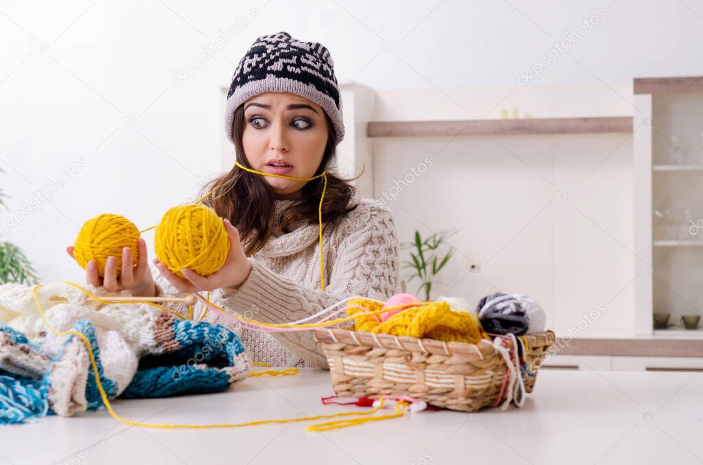 Young beautiful woman knitting at home