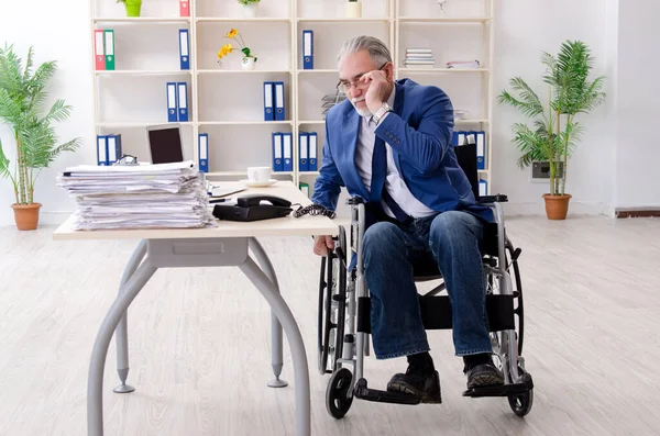 Employé âgé en fauteuil roulant travaillant au bureau — Photo