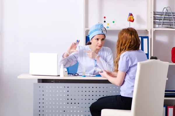 Mujer joven visitando a doctora otorrinolaringóloga — Foto de Stock