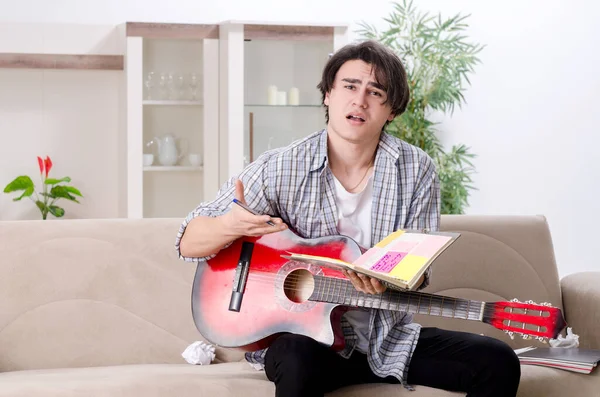 Jovem com guitarra em casa — Fotografia de Stock