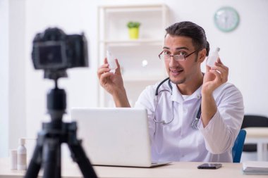 Genç erkek doktor blogu için video kaydediyor.
