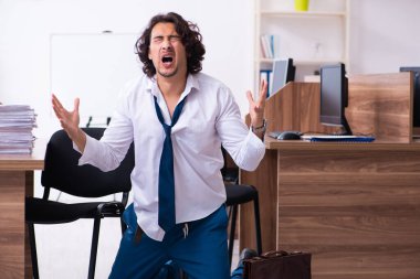 Genç bir erkek işçi aşırı işten memnun değil.