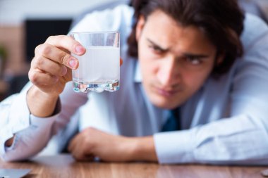 Hasta erkek çalışan ofiste acı çekiyor.