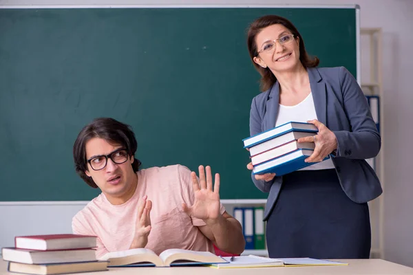 Old female teacher and male student in the classroom — Stock Photo, Image