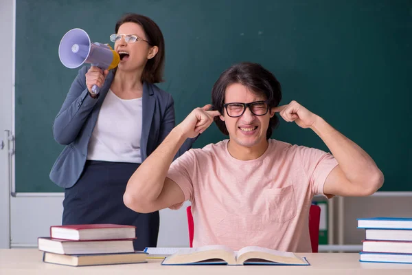 Gammal kvinnlig lärare och manlig student i klassrummet — Stockfoto