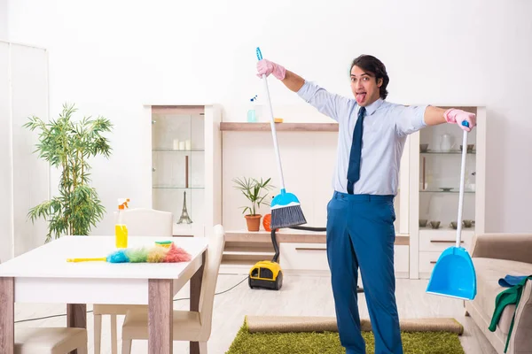 Молодий бізнесмен прибирає будинок — стокове фото