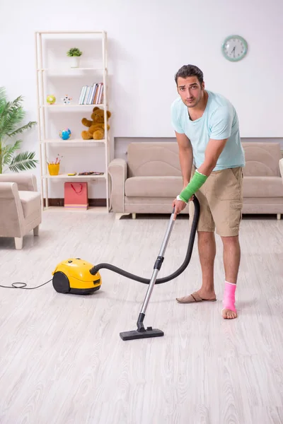 Young injured man cleaning the house