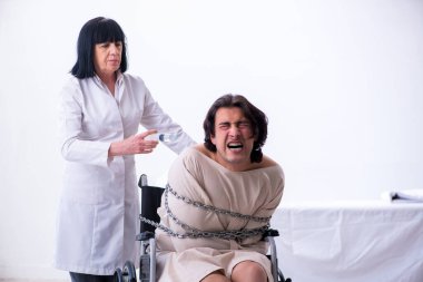 Yaşlı kadın psikiyatrist genç erkek hastayı ziyaret ediyor