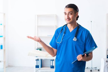Klinikte çalışan genç erkek doktor.