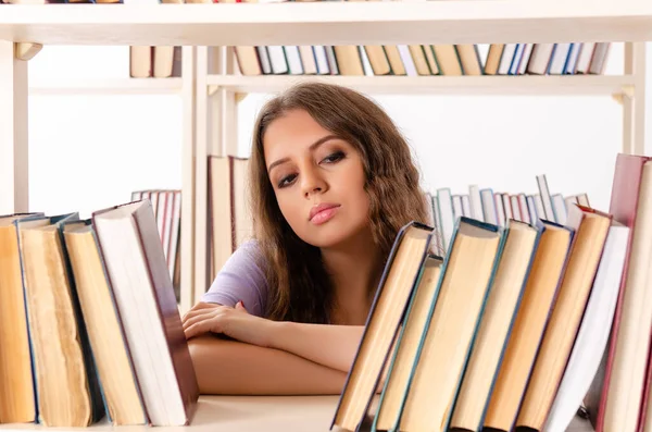 Jonge vrouwelijke student bereidt examens in de bibliotheek voor — Stockfoto