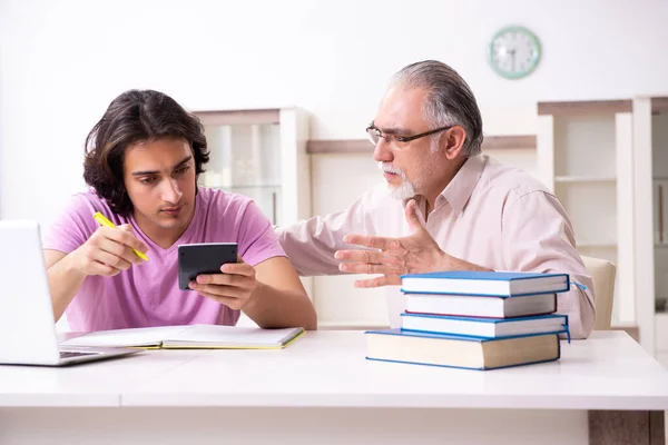 Yaşlı baba sınav hazırlıklarında oğluna yardım ediyor. — Stok fotoğraf