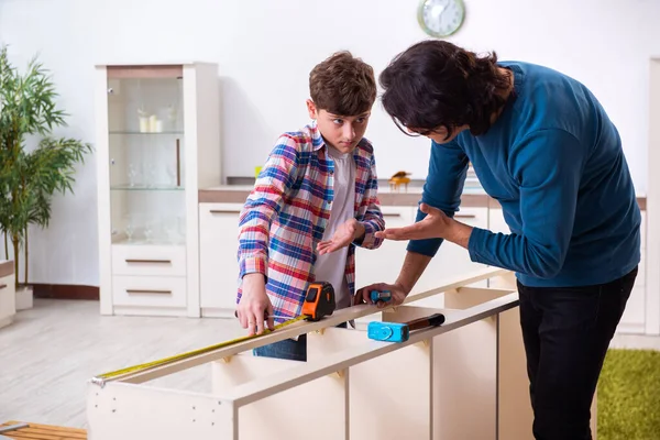 Jonge timmerman die zijn zoon onderwijst — Stockfoto