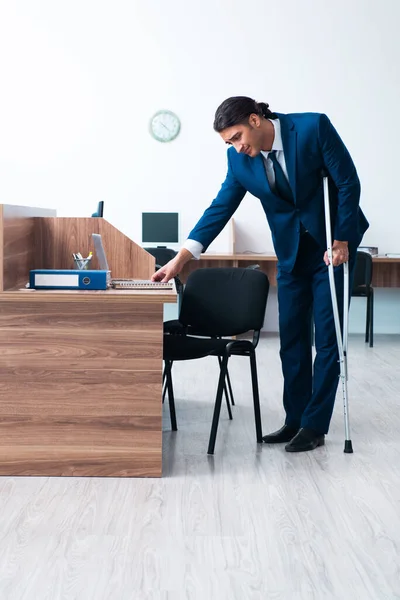 Young leg injured employee in the office — Stock Photo, Image