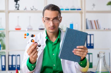 Laboratuvardaki genç erkek kimyacı öğretmen.