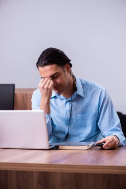 Masasında çalışan çağrı merkezi operatörü.