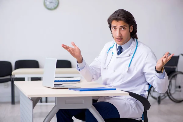 Jonge knappe dokter werkt in de kliniek — Stockfoto