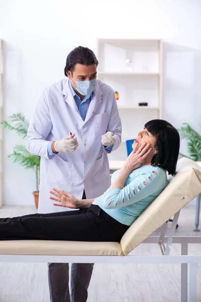 Oude vrouw bezoekt jonge dokter tandarts — Stockfoto