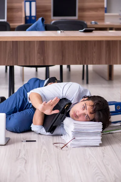 Junge männliche Mitarbeiter und zu viele Arbeit im Büro — Stockfoto