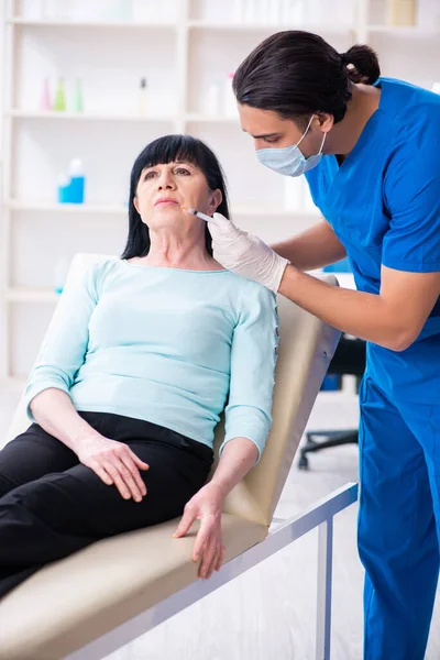 Mulher velha visitando médico masculino para cirurgia plástica — Fotografia de Stock