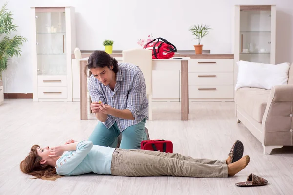 Pareja joven en concepto de primeros auxilios en casa — Foto de Stock