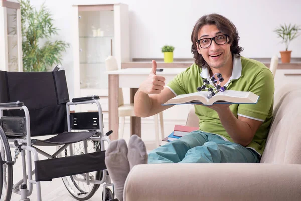 Jeune étudiant en fauteuil roulant à la maison — Photo