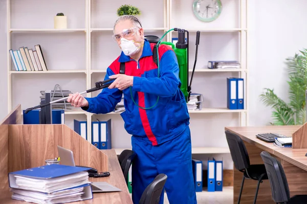 Ancien entrepreneur professionnel faisant de la lutte antiparasitaire au bureau — Photo