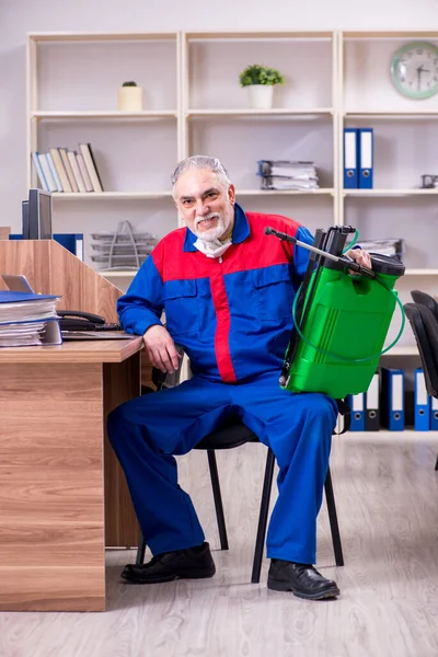 Oude professionele aannemer doet ongediertebestrijding in het kantoor — Stockfoto