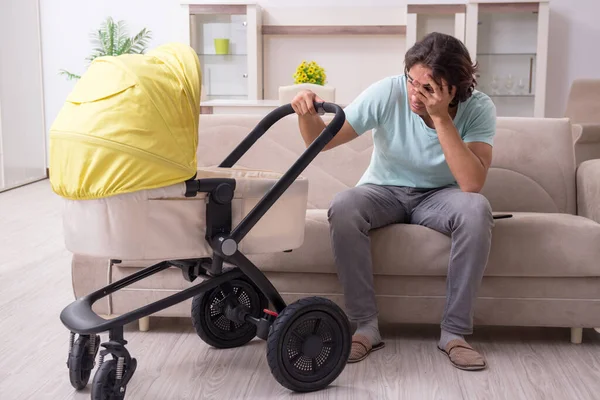 Young man looking after baby in pram — Stock Photo, Image