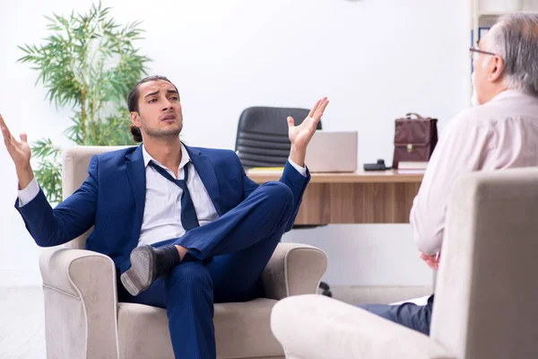 Jongeman op bezoek bij oude mannelijke dokter psycholoog — Stockfoto