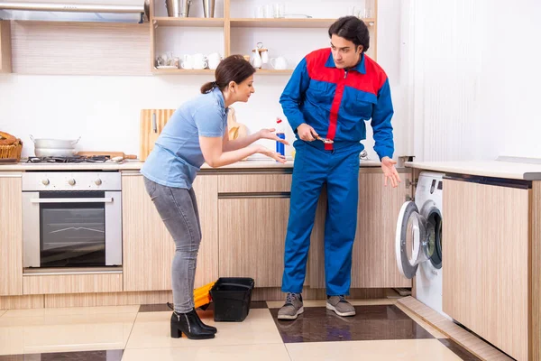 Young male repairman repairing washing machine