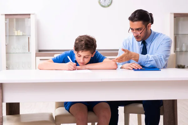 Upptagen far hjälpa sin son att förbereda sig för examen — Stockfoto