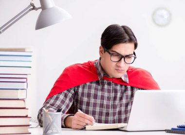 Dizüstü bilgisayarı olan süper kahraman öğrenci sınavlara hazırlanıyor.