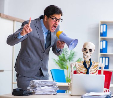 Kızgın patron iskelet çalışanına bağırıyor.