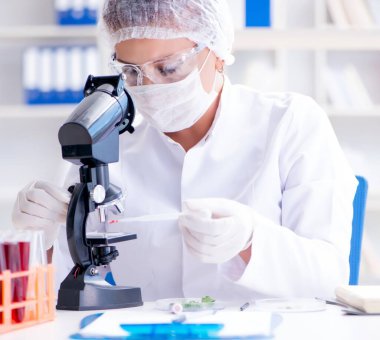 Bir laboratuarda deney yapan kadın bir bilim adamı.