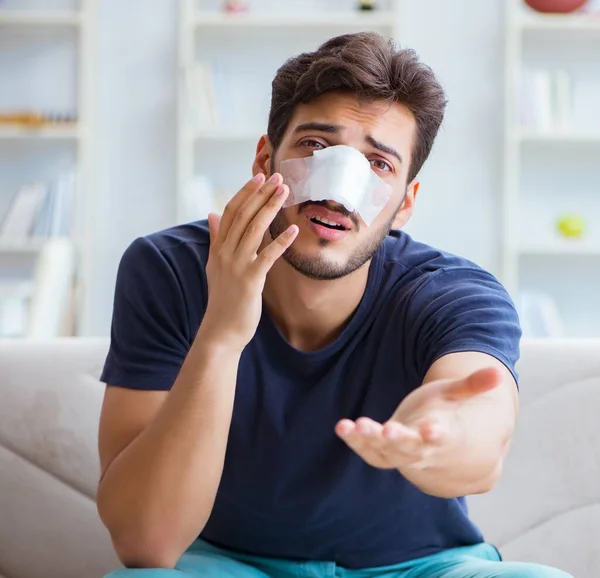 Hombre joven recuperando la curación en casa después de la cirugía plástica nariz — Foto de Stock