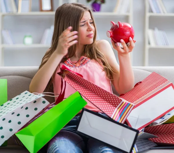 Jonge vrouw met boodschappentassen binnen op de bank — Stockfoto