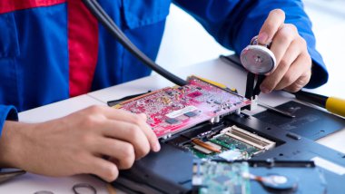 Bilgisayar dizüstü bilgisayarının tamirinde çalışan tamirci.