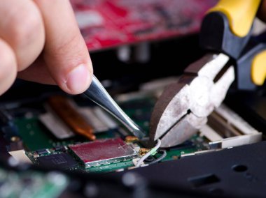 Bilgisayar dizüstü bilgisayarının tamirinde çalışan tamirci.