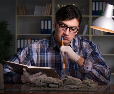 Arkeolog geç saatlere kadar ofiste çalışıyor.